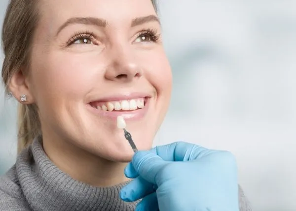 How Much Are Veneers in BC? Complete 2025 Guide to Costs, Types & Insurance Coverage 3 Dentist showing veneer options to female patient with mirror — how much are veneers in BC